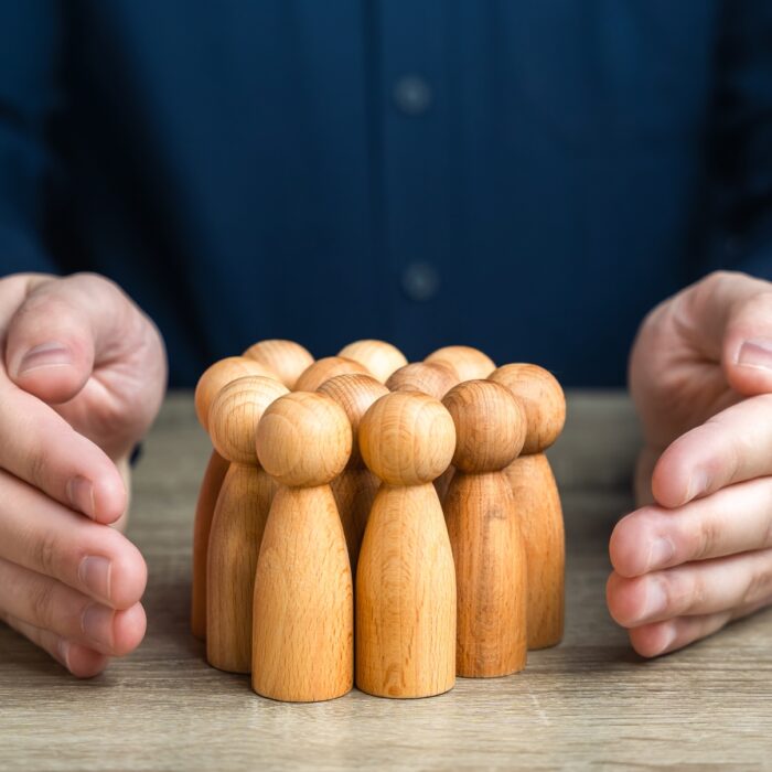 A man protects human figures with his hands.