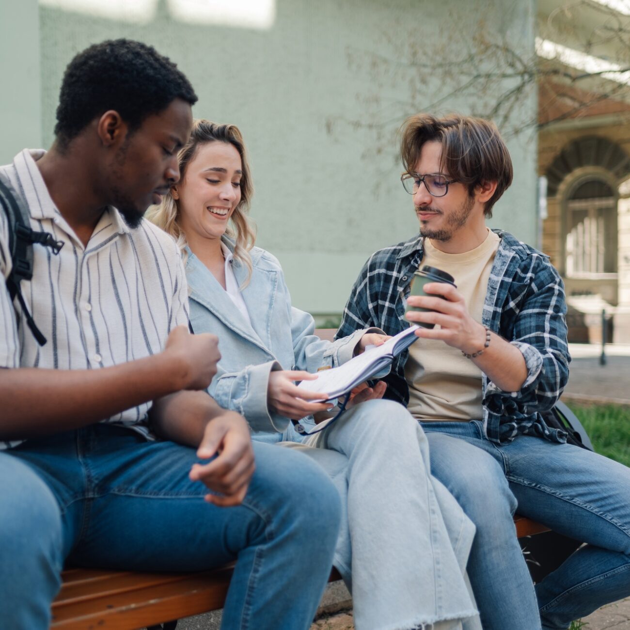 University students studying and chatting on bench